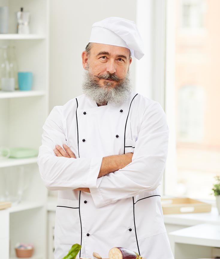 Chef cruzado de brazos posando para retrato.